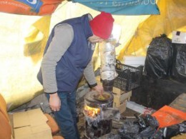 Seyyar satıcılar açık havada sobayla ısınıyor