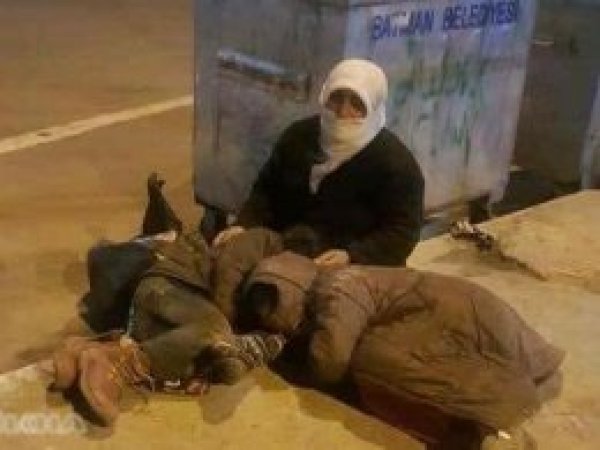 Çöp konteynerin yanında oturan anne ve çocuklarıyla ilgili açıklama